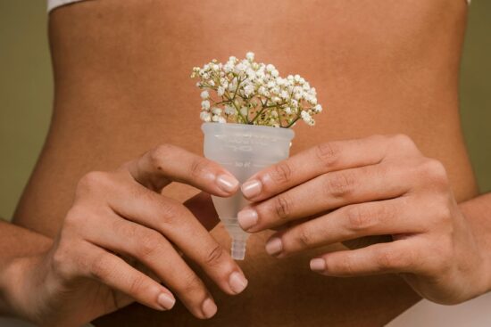 A creative depiction of femininity with a menstrual cup and flowers, emphasizing health and intimacy.